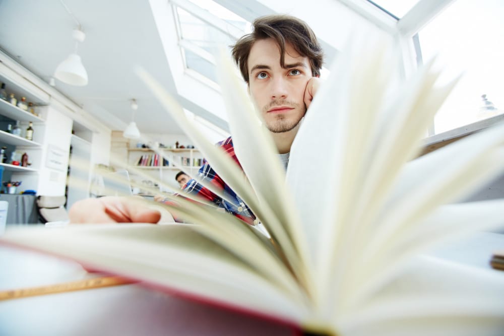 jeune homme feuilletant un livre