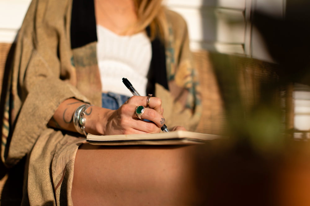 femme écrivant sur un carnet au soleil